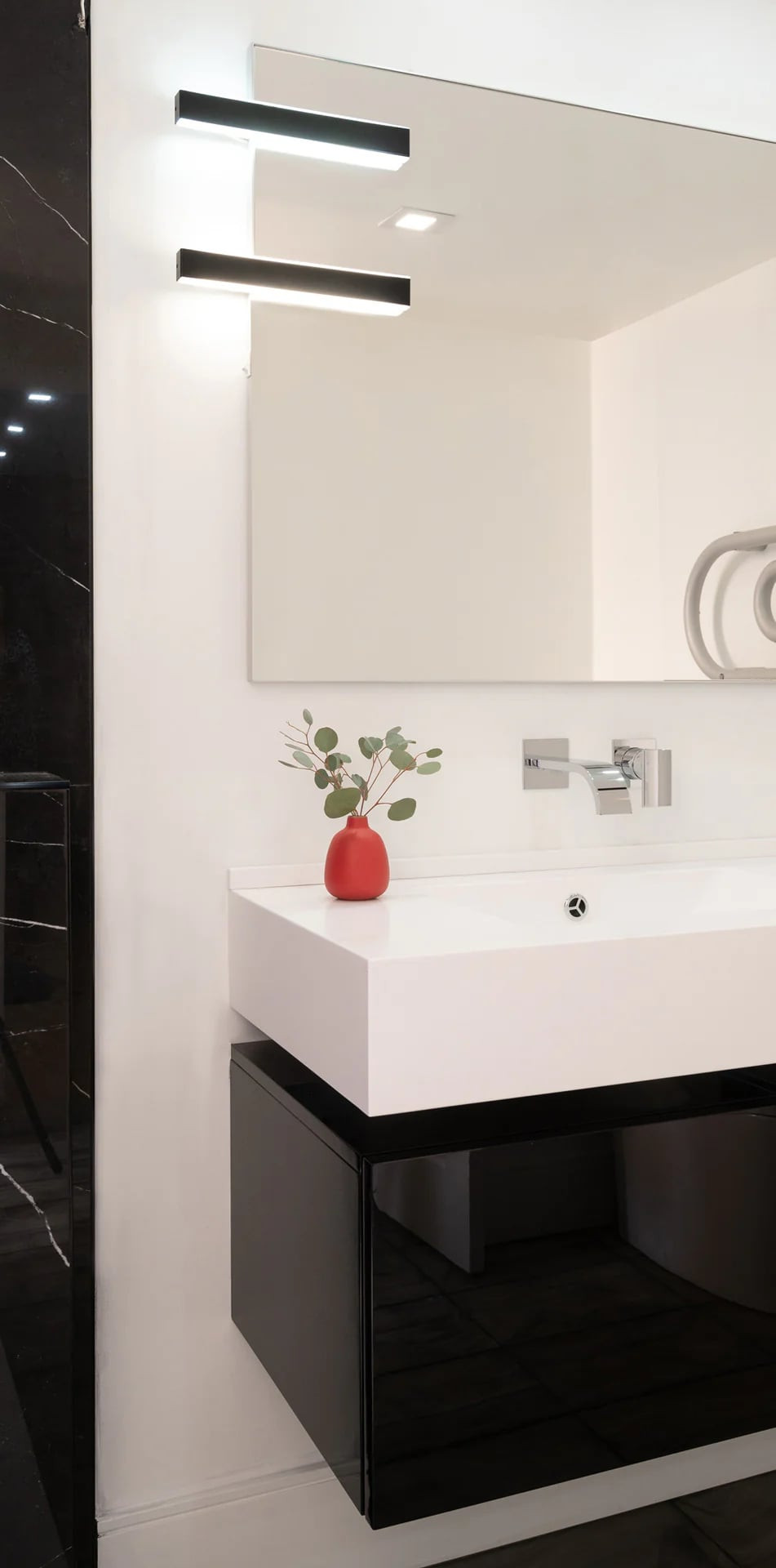White gloss vanity with a black basin surround and a mirror