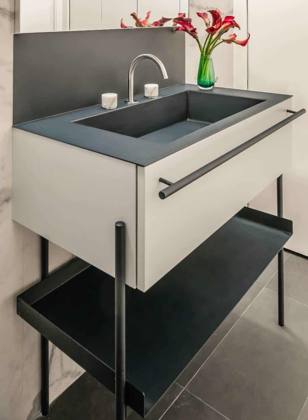 Small bathroom with blue tiles, a dark wood vanity and a white basin