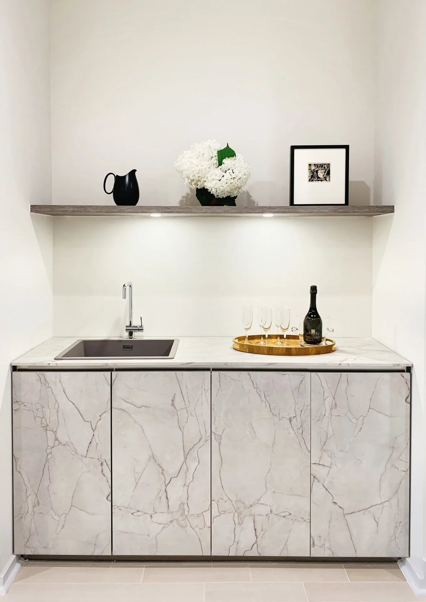 White open bookcase dividing a living room from the stairs