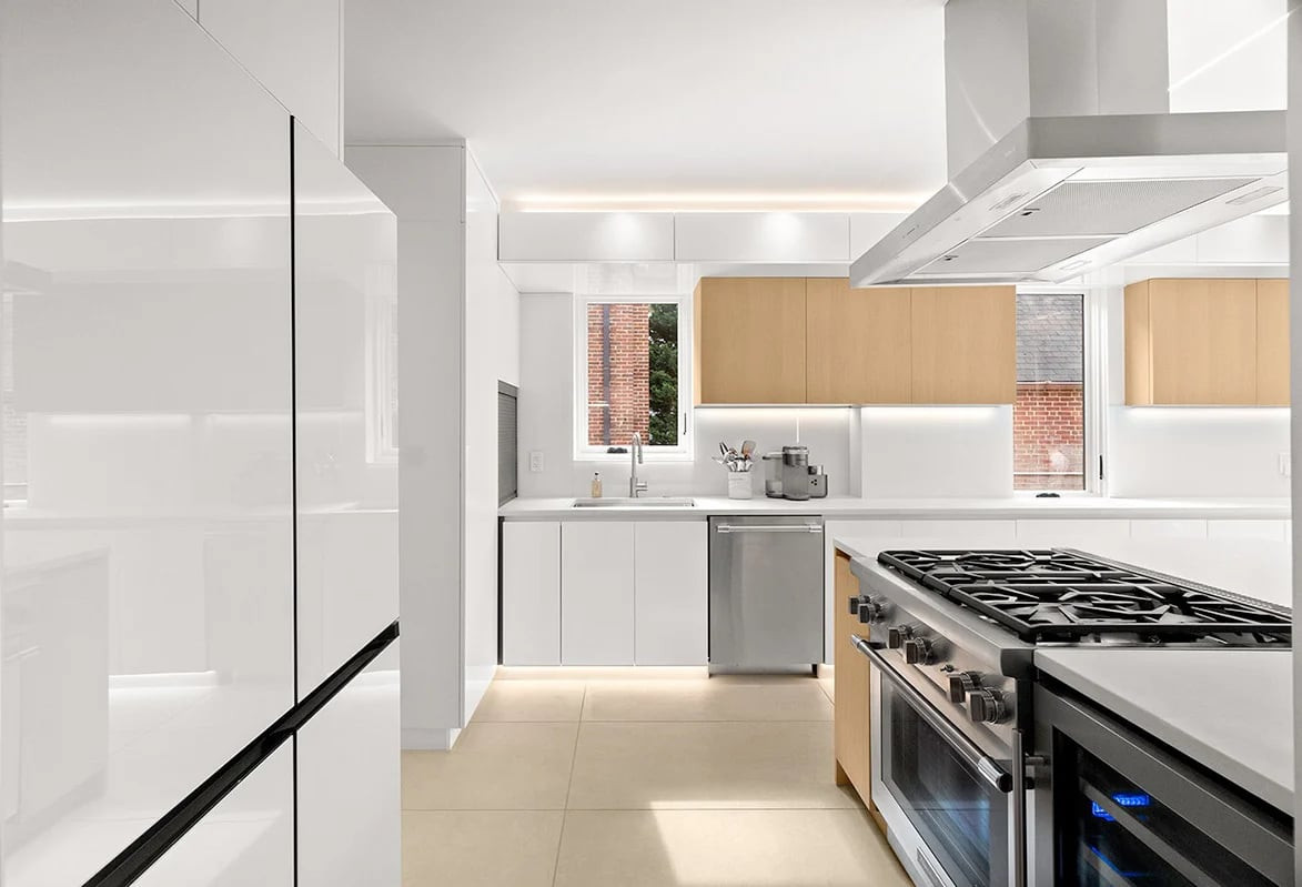Kitchen with orange wall units and greens on a white island