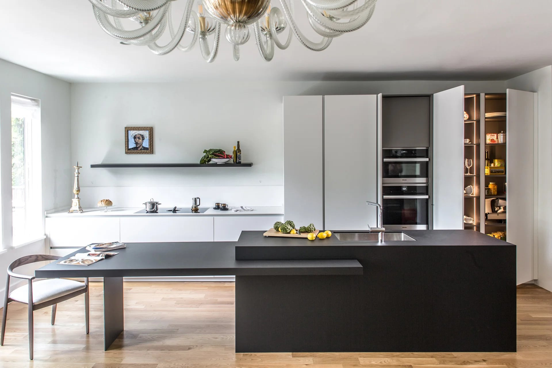 White matt lacquered kitchen in an L with a Fenix island and pendant lights