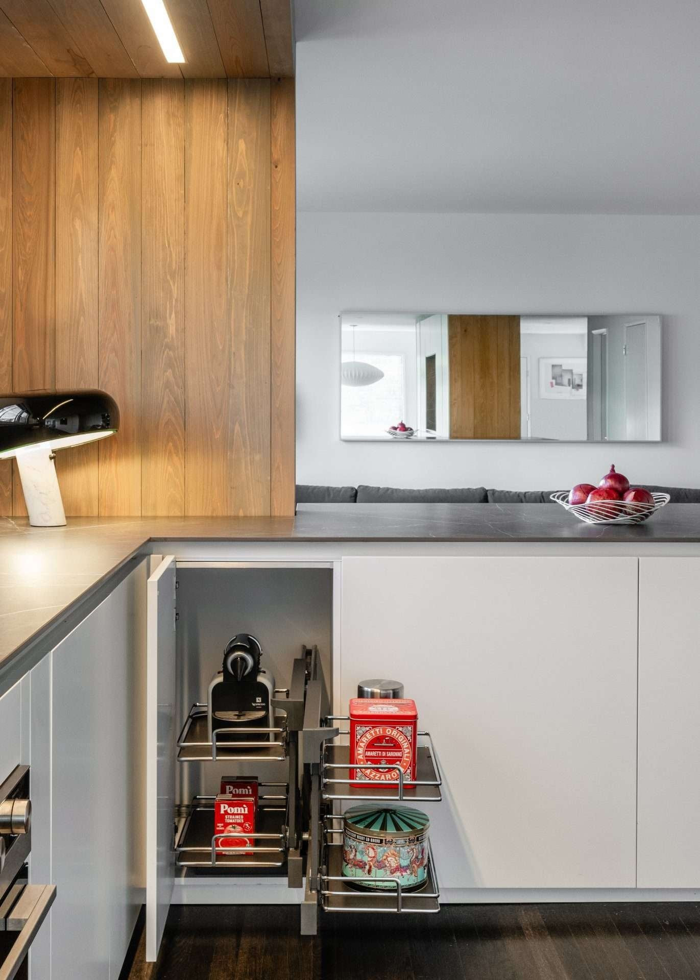 Corner unit in matt white with a wood-clad column and open pull-out