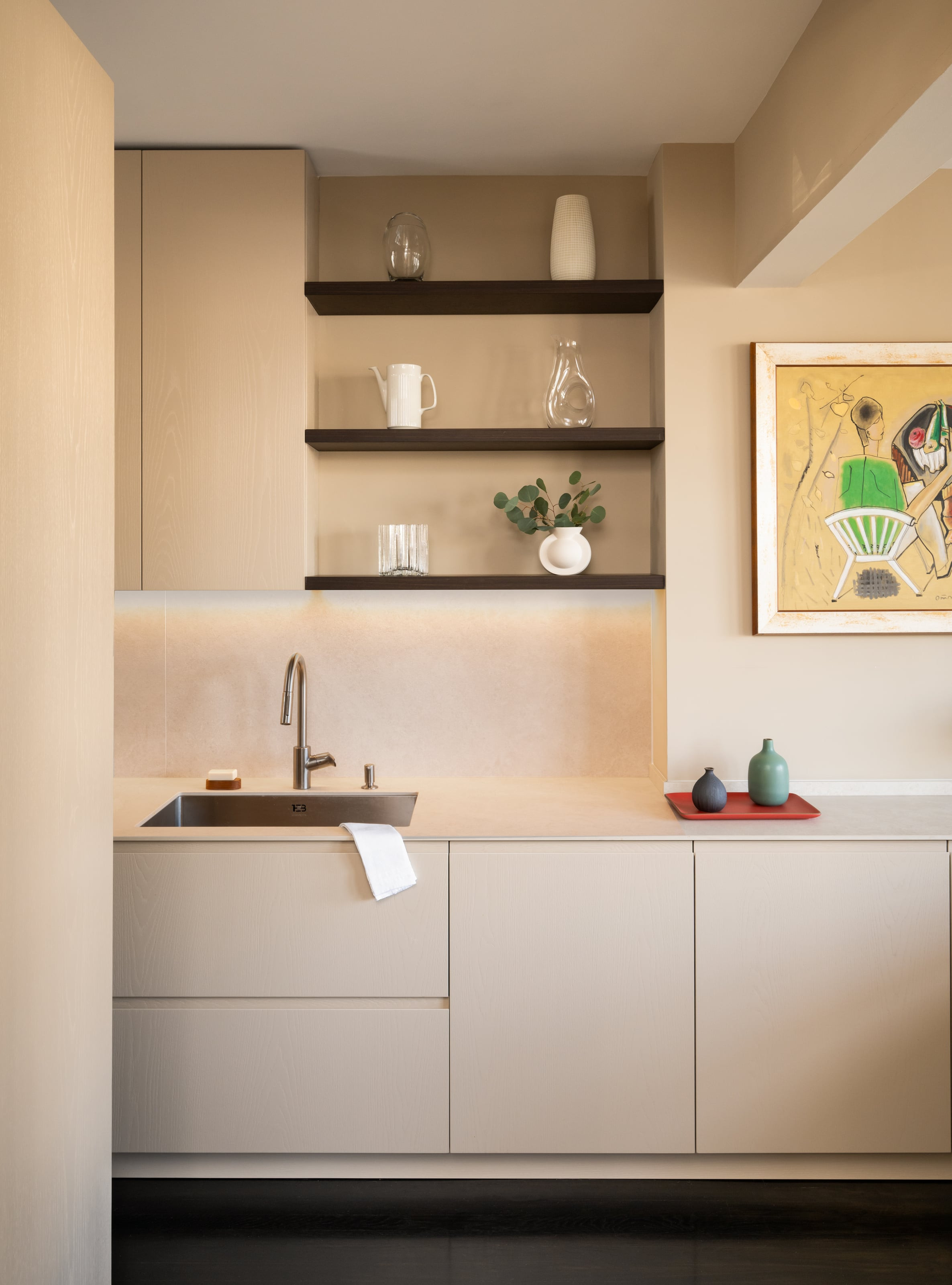 Grey painted wall units over oak base cabinets with a blue stool